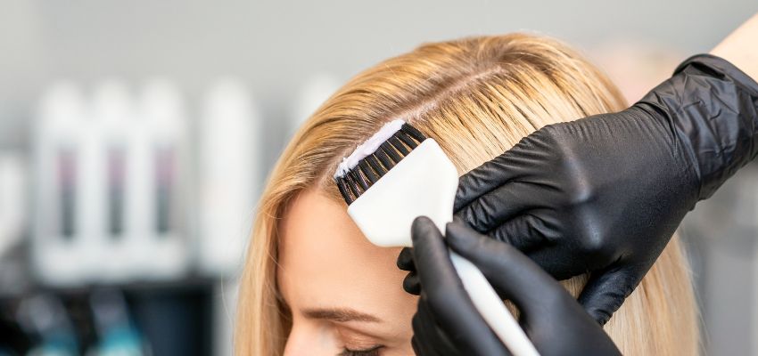 hair-color-correction2 Close-up of hair color correction treatment on blonde hair with applicator tool