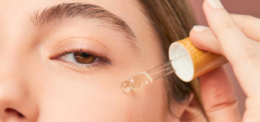 The woman uses essential oils on her face.
