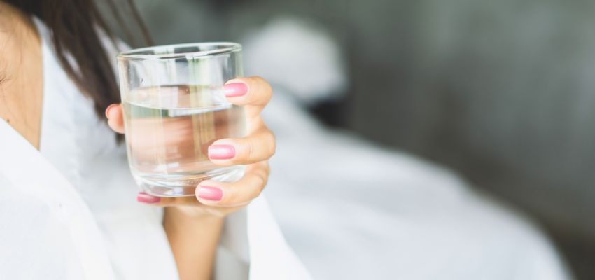 Woman drinking water as one of the simplest natural beauty remedies