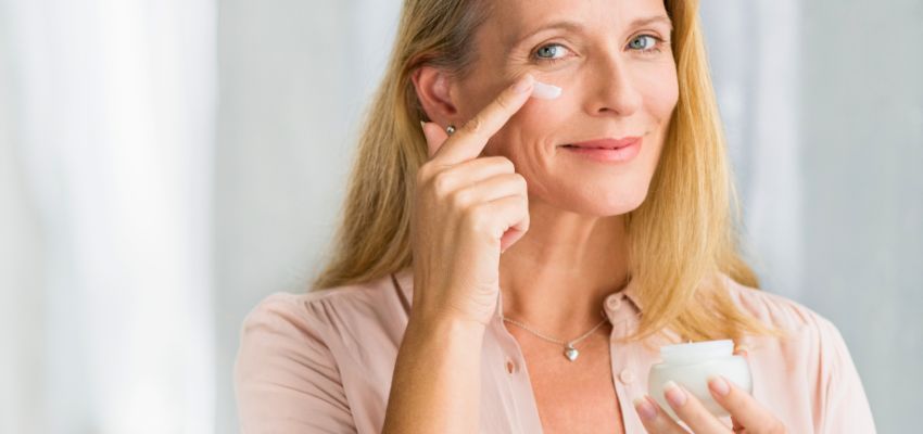 Woman applying face cream after verifying products with a skincare ingredient checker.