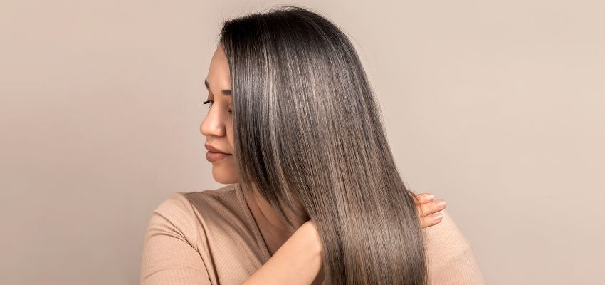 The woman has a rooty blonde hairstyle.