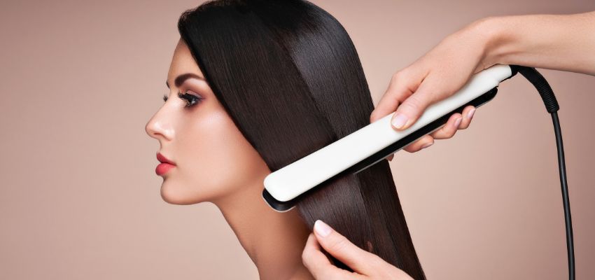 Woman’s hair being flat-ironed during a keratin treatment process.