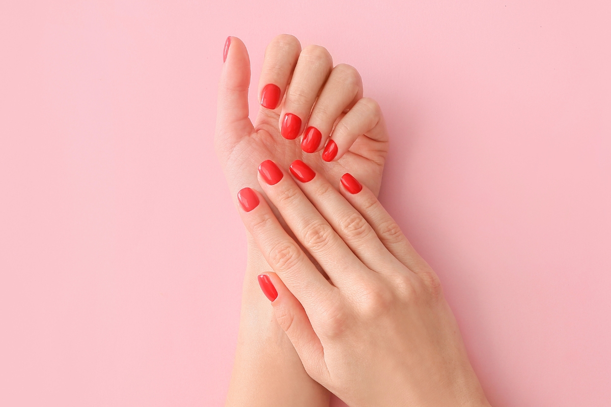 Beautiful hands with flawless red manicured nails, showcasing the smooth, strong results of what does builder gel do.