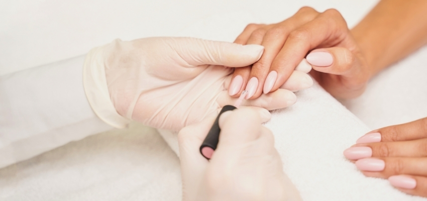 Professional nail technician applying builder gel during a manicure, illustrating what does builder gel do to create durable, natural-looking nails.