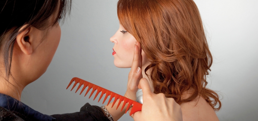 celebrity-hairstylist1 Professional celebrity hairstylist styling a client’s glamorous red hair with a wide-tooth comb.