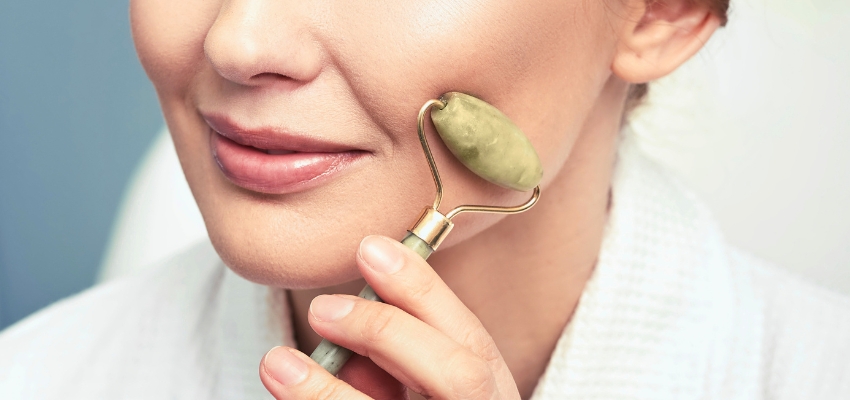 how-to-use-jade-roller4 Close-up of a woman applying a jade roller to her jawline, showing how to use jade roller correctly.