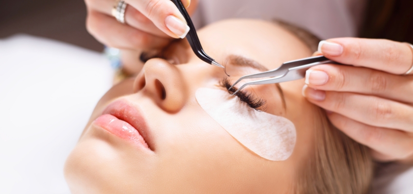 lash-extension-aftercare4 Lash technician applying extensions with tweezers, underscoring the value of professional lash extension aftercare.